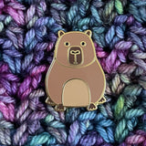 Capybara pin badge on a colorful yarn background