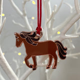Decorative horse ornament with a red string on a branch background